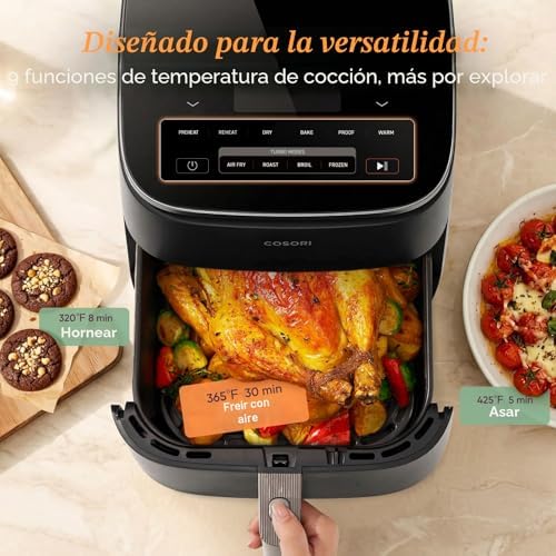 Mano retirando la canasta cuadrada del COSORI TurboBlaze con pollo y vegetales recién horneados