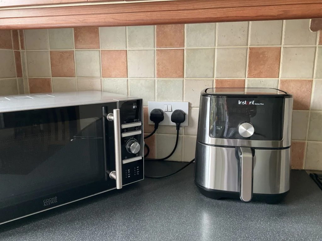 Instant Vortex Plus 6 Qt instalado y conectado en la meseta de la cocina, junto al microondas, listo para usarse